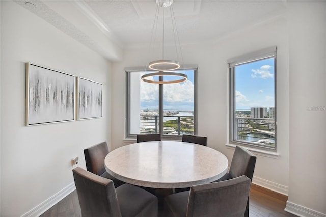 dining area featuring baseboards, dark wood finished floors, and a chandelier