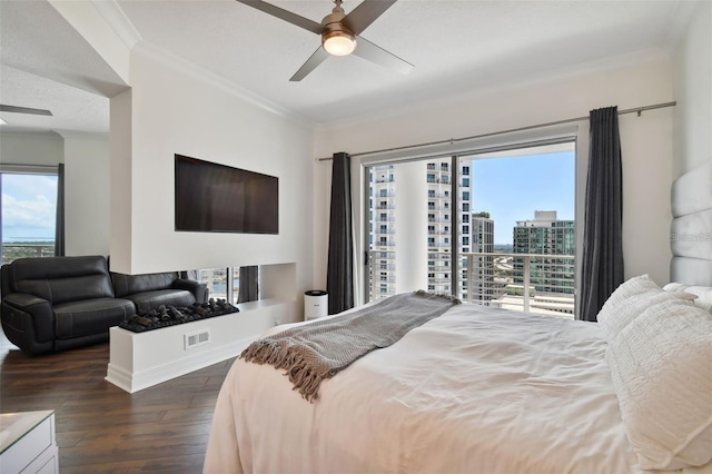 bedroom featuring dark wood-style flooring, crown molding, and ceiling fan