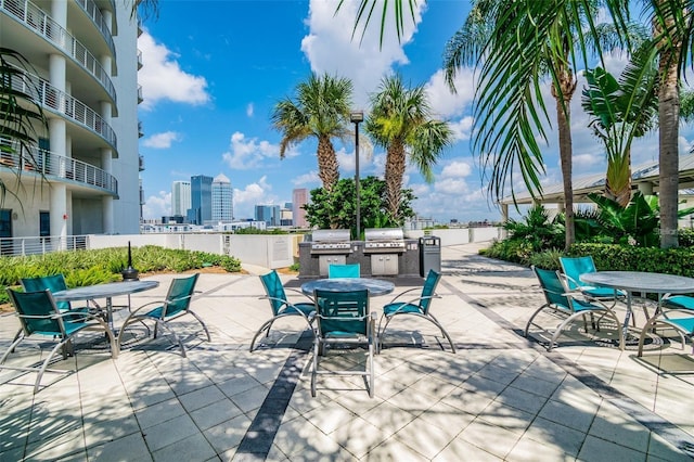 view of patio with a skyline view, an outdoor kitchen, a grill, and outdoor dining space