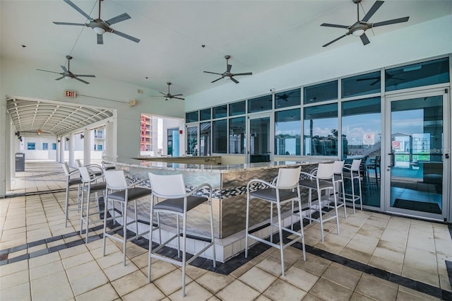 kitchen with tile patterned floors, a towering ceiling, and a ceiling fan