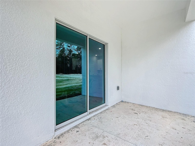 12197 SW 76th Ln, Dunnellon, FL 34432 - view of exterior entry with stucco siding and a patio area