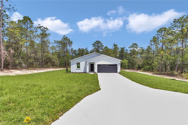 12197 SW 76th Ln, Dunnellon, FL 34432 - view of front of property with a front yard, concrete driveway, and board and batten siding