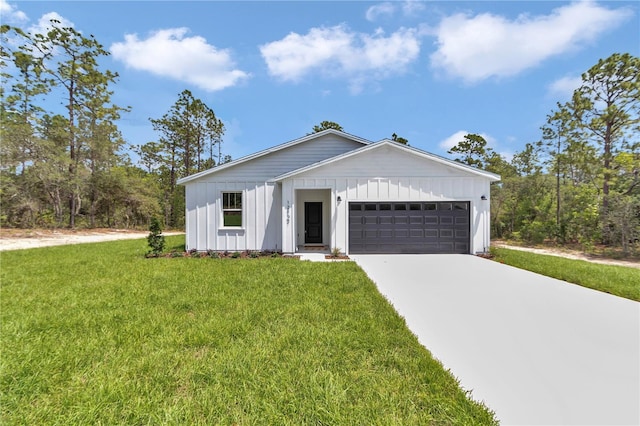 12197 SW 76th Ln, Dunnellon, FL 34432 - view of front of house with board and batten siding, an attached garage, a front yard, and concrete driveway