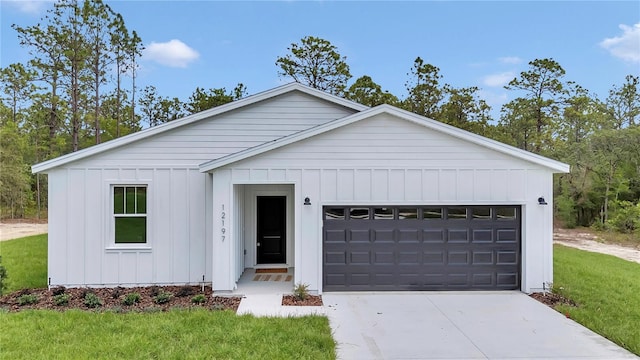12197 SW 76th Ln, Dunnellon, FL 34432 - view of front of house featuring board and batten siding, concrete driveway, a front lawn, and a garage