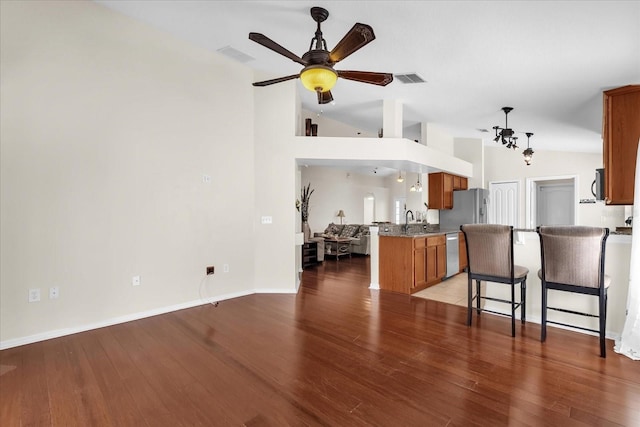 14617 Keelford Way, Orlando, FL 32824 - kitchen with dishwasher, lofted ceiling, brown cabinets, a ceiling fan, and a peninsula