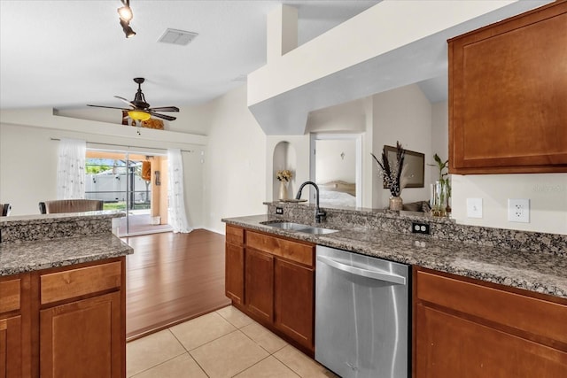 14617 Keelford Way, Orlando, FL 32824 - kitchen with dishwasher, a sink, ceiling fan, brown cabinetry, and dark stone counters