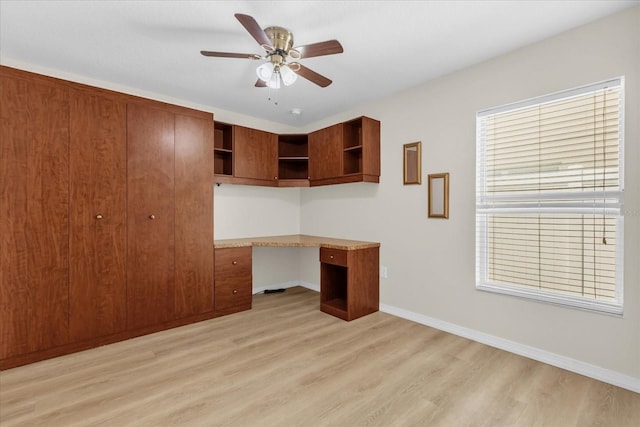 14617 Keelford Way, Orlando, FL 32824 - unfurnished office with built in desk, light wood-style flooring, a ceiling fan, and baseboards