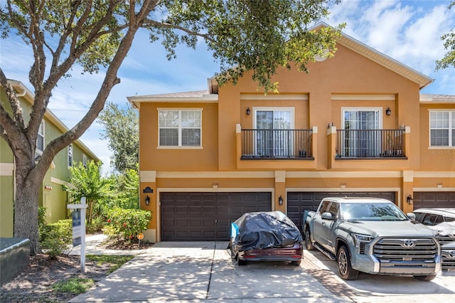 2330 Little Gem Loop, Sanford, FL 32773 - view of property featuring stucco siding, a garage, driveway, and a balcony