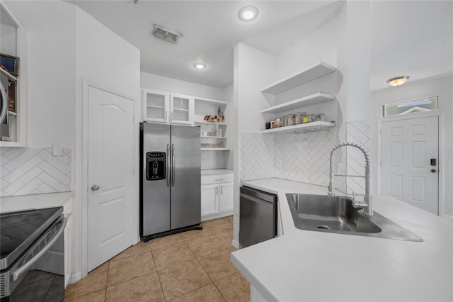 2330 Little Gem Loop, Sanford, FL 32773 - kitchen with stainless steel appliances, a sink, open shelves, white cabinets, and decorative backsplash