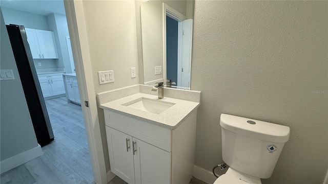 851 Marion Oaks Mnr, Ocala, FL 34473 - bathroom featuring vanity, wood finished floors, toilet, and a textured wall