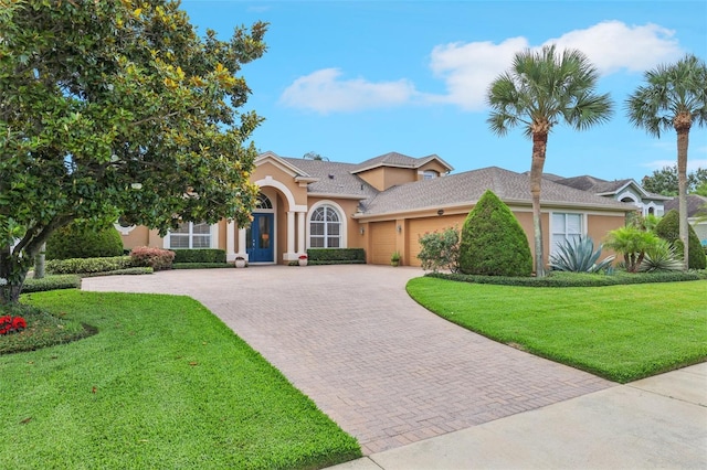 13524 Glynshel Dr, Winter Garden, FL 34787 - view of front facade featuring a garage, stucco siding, decorative driveway, and a front yard