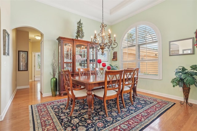 13524 Glynshel Dr, Winter Garden, FL 34787 - dining room with arched walkways, light wood finished floors, a chandelier, ornamental molding, and baseboards