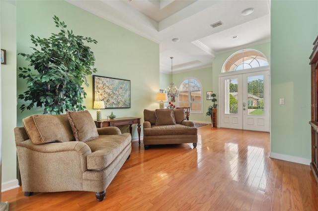 13524 Glynshel Dr, Winter Garden, FL 34787 - living room featuring crown molding, a towering ceiling, baseboards, light wood-style flooring, and a chandelier