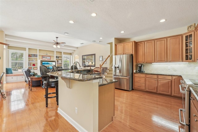 13524 Glynshel Dr, Winter Garden, FL 34787 - kitchen with stainless steel appliances, dark stone counters, a breakfast bar, healthy amount of natural light, and recessed lighting