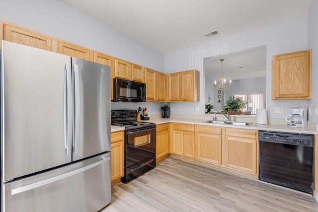 2706 Camaro Dr, Kissimmee, FL 34746 - kitchen featuring black appliances, a sink, light brown cabinets, a chandelier, and light wood-style flooring