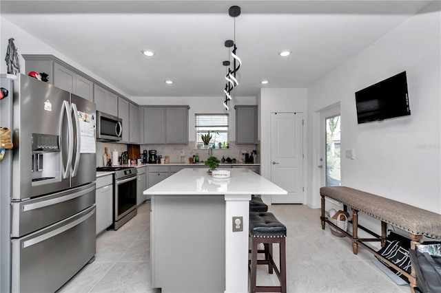 8413 SW 54th Loop, Ocala, FL 34481 - kitchen with stainless steel appliances, gray cabinets, plenty of natural light, a breakfast bar, and recessed lighting