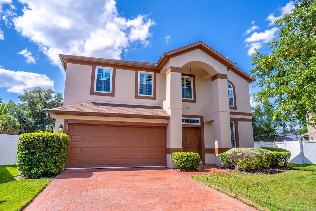 1676 Song Sparrow Ct, Sanford, FL 32773 - view of front facade featuring stucco siding, an attached garage, and decorative driveway