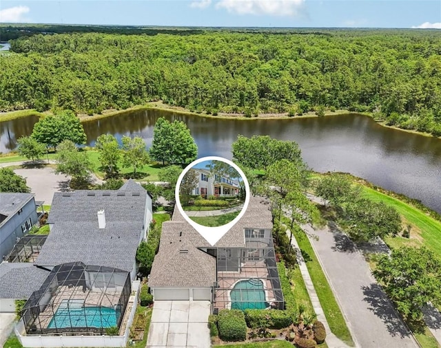 drone / aerial view of a pool, a forest, and a large body of water