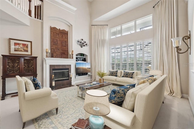 living room with a towering ceiling and a fireplace