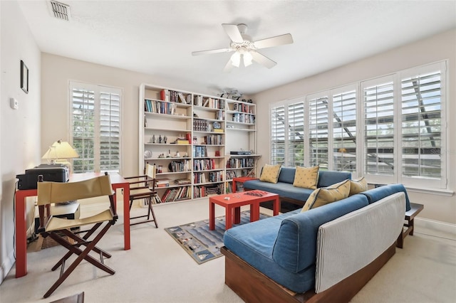 living room with plenty of natural light, ceiling fan, and carpet flooring