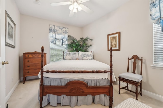 bedroom featuring light colored carpet, baseboards, and ceiling fan