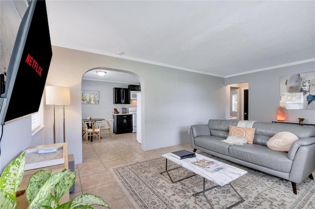 living room featuring arched walkways, ornamental molding, and light tile patterned floors