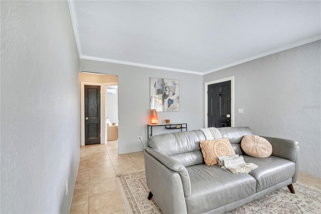 living area featuring arched walkways, ornamental molding, and light tile patterned floors