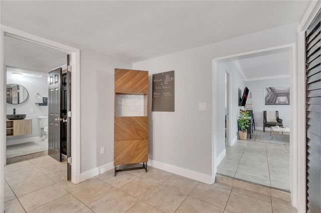 hallway featuring light tile patterned flooring and baseboards