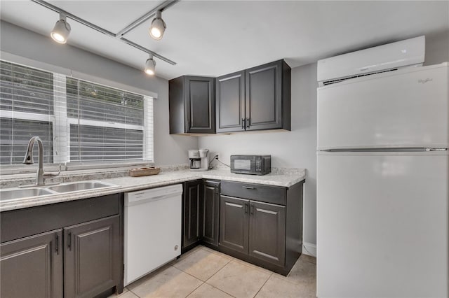 kitchen with white appliances, a sink, light tile patterned floors, light countertops, and rail lighting