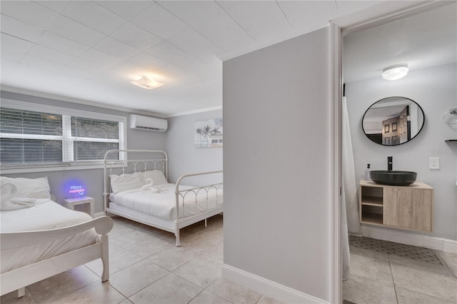 bedroom featuring a wall unit AC, a sink, baseboards, light tile patterned floors, and crown molding