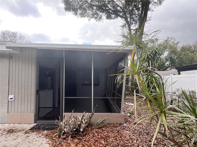 back of house with a sunroom and fence