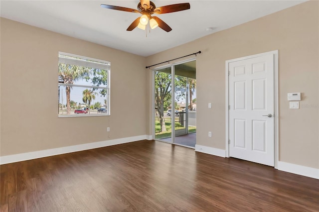 unfurnished room with wood finished floors, baseboards, and a ceiling fan