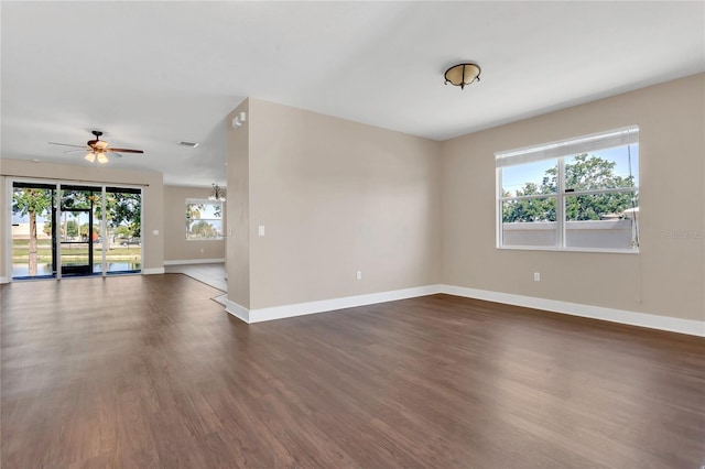 spare room with dark wood-style floors, baseboards, and ceiling fan