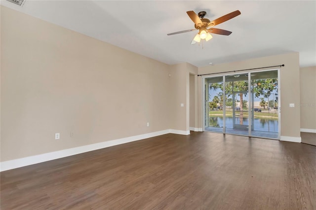 unfurnished room with baseboards, dark wood-type flooring, and ceiling fan