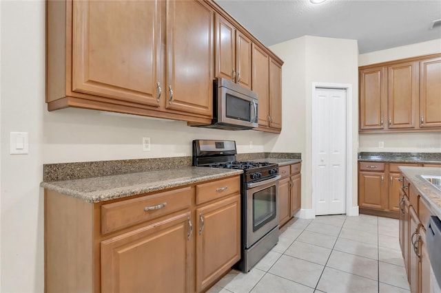 kitchen with appliances with stainless steel finishes and light tile patterned floors