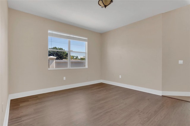 empty room with dark wood-style floors and baseboards