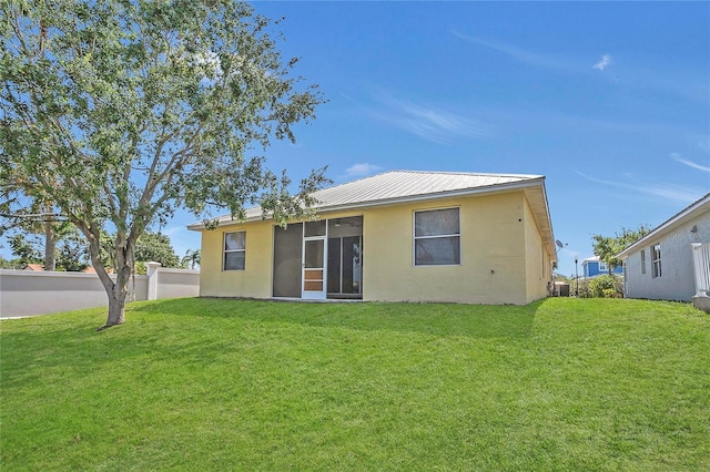 back of house featuring stucco siding and metal roof