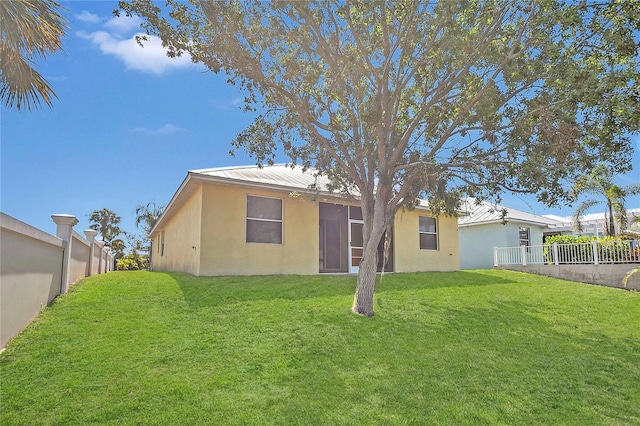 back of property with stucco siding and metal roof