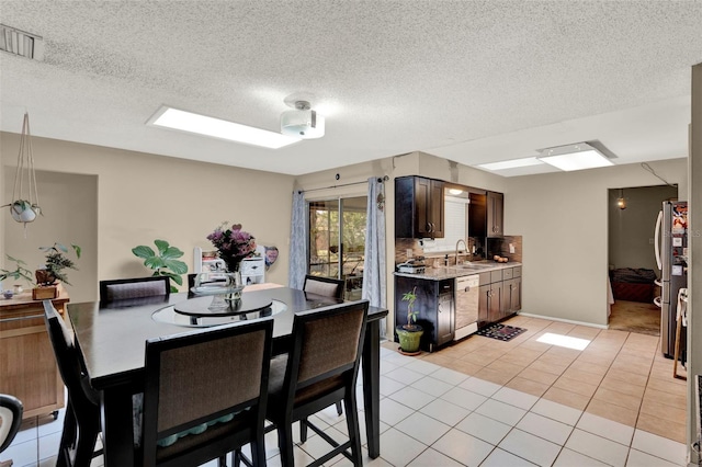 dining space with light tile patterned floors and a textured ceiling