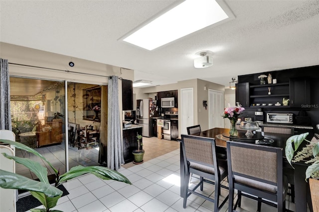 dining room featuring light tile patterned flooring and a textured ceiling