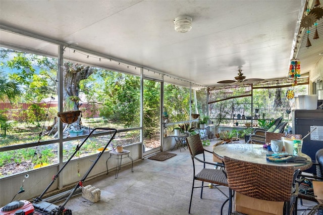 sunroom / solarium with ceiling fan, healthy amount of natural light, and outdoor dining area