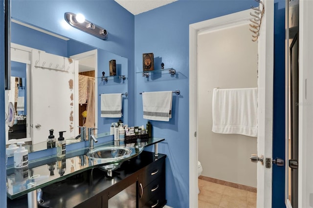 full bathroom featuring toilet, tile patterned floors, vanity, and baseboards