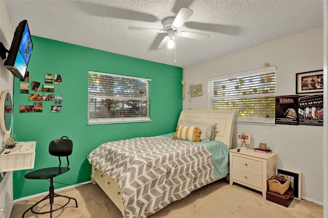 bedroom with carpet flooring, a textured ceiling, a ceiling fan, and baseboards