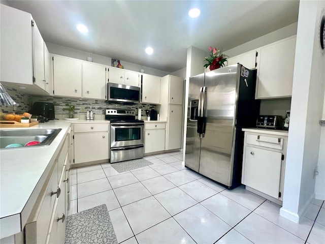2376 Flamingo Lakes Dr, Kissimmee, FL 34743 - kitchen with stainless steel appliances, tasteful backsplash, a sink, light countertops, and white cabinets