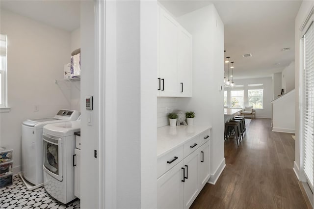 15408 Lebeau Loop, Winter Garden, FL 34787 - laundry area with separate washer and dryer, dark wood-style flooring, cabinet space, and baseboards