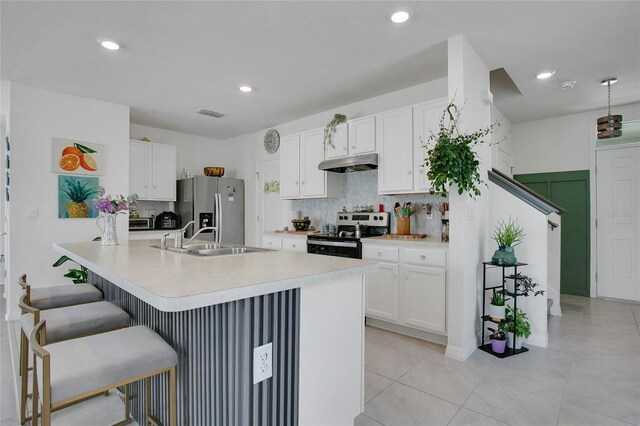 2834 Common Crane Ct, Saint Cloud, FL 34773 - kitchen with stainless steel appliances, under cabinet range hood, a sink, decorative backsplash, and recessed lighting