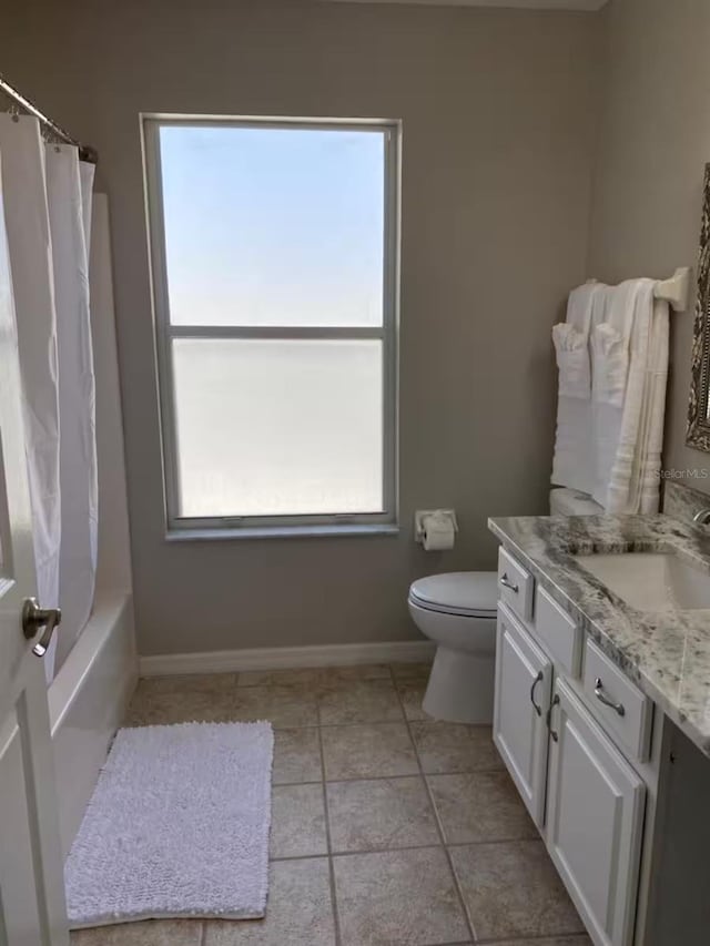 full bathroom featuring toilet, baseboards, vanity, and shower / tub combo