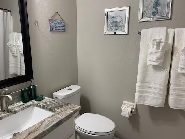 bathroom featuring toilet and vanity