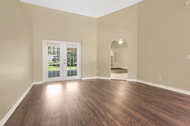 922 Hatteras Ave, Minneola, FL 34715 - spare room with french doors, dark wood-style floors, arched walkways, baseboards, and a towering ceiling