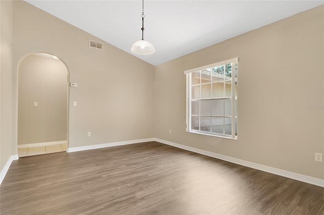 922 Hatteras Ave, Minneola, FL 34715 - empty room featuring arched walkways, wood finished floors, baseboards, and lofted ceiling